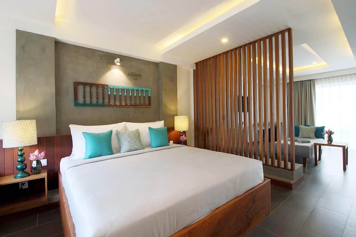 A modern hotel room with a large bed, wooden headboard, and a decorative wall piece.
