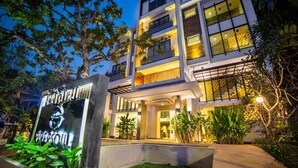 A modern hotel with a well-lit entrance, a large sign, and a landscaped garden area. - Riversoul Boutique (Siem Reap)