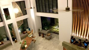 A spacious, modern interior with a high ceiling, a central bar area, and a seating area with a sofa and chairs. - Riversoul Boutique (Siem Reap)