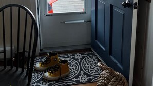 Een deur met een codeerapparaat, een stoel en een paar gele schoenen op een kamerbreed tapijt.