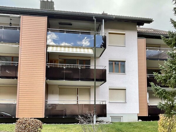 Un immeuble résidentiel à plusieurs étages, doté de balcons, de grandes fenêtres et d’un toit plat.