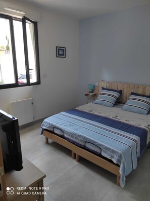 A bedroom with a bed, a bedside table, a window, and a radiator. - New villa in Fonsainte neighborhood near beach/station, garden, spa, BBQ, private parking (La Ciotat)