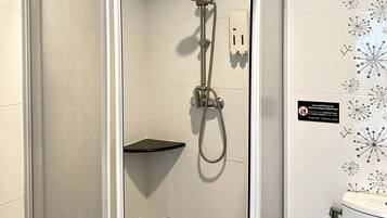 A shower with a handheld showerhead and a wall-mounted faucet.