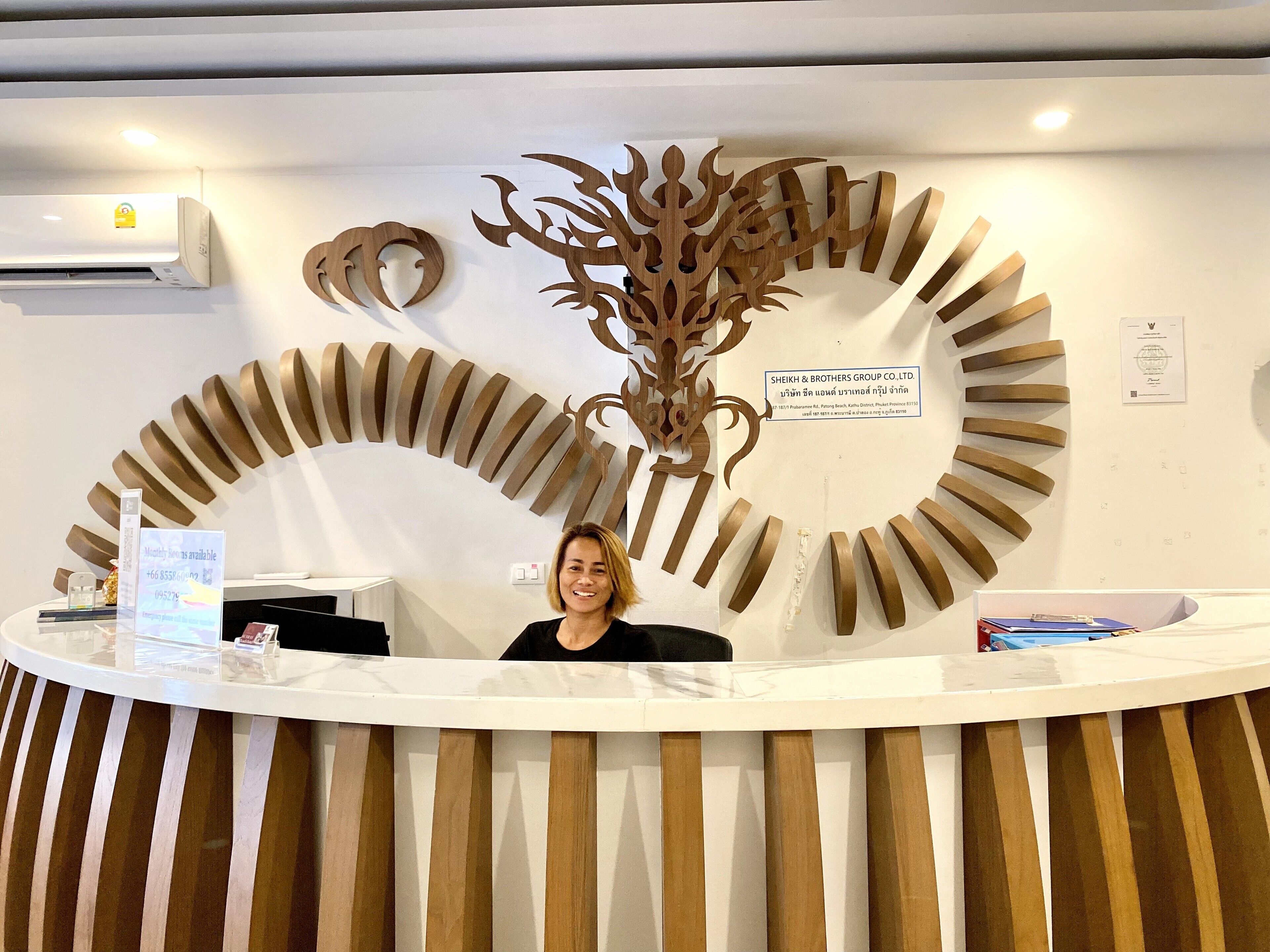 A reception desk with a decorative wooden panel and a sign for SHEIKH & BROTHERS GROUP CO., LTD.