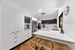 Enjoy cooking in this well-equipped kitchen with a central island, oven, and stainless steel appliances.