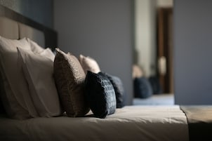 Una cama con varias almohadas y un cabecero.