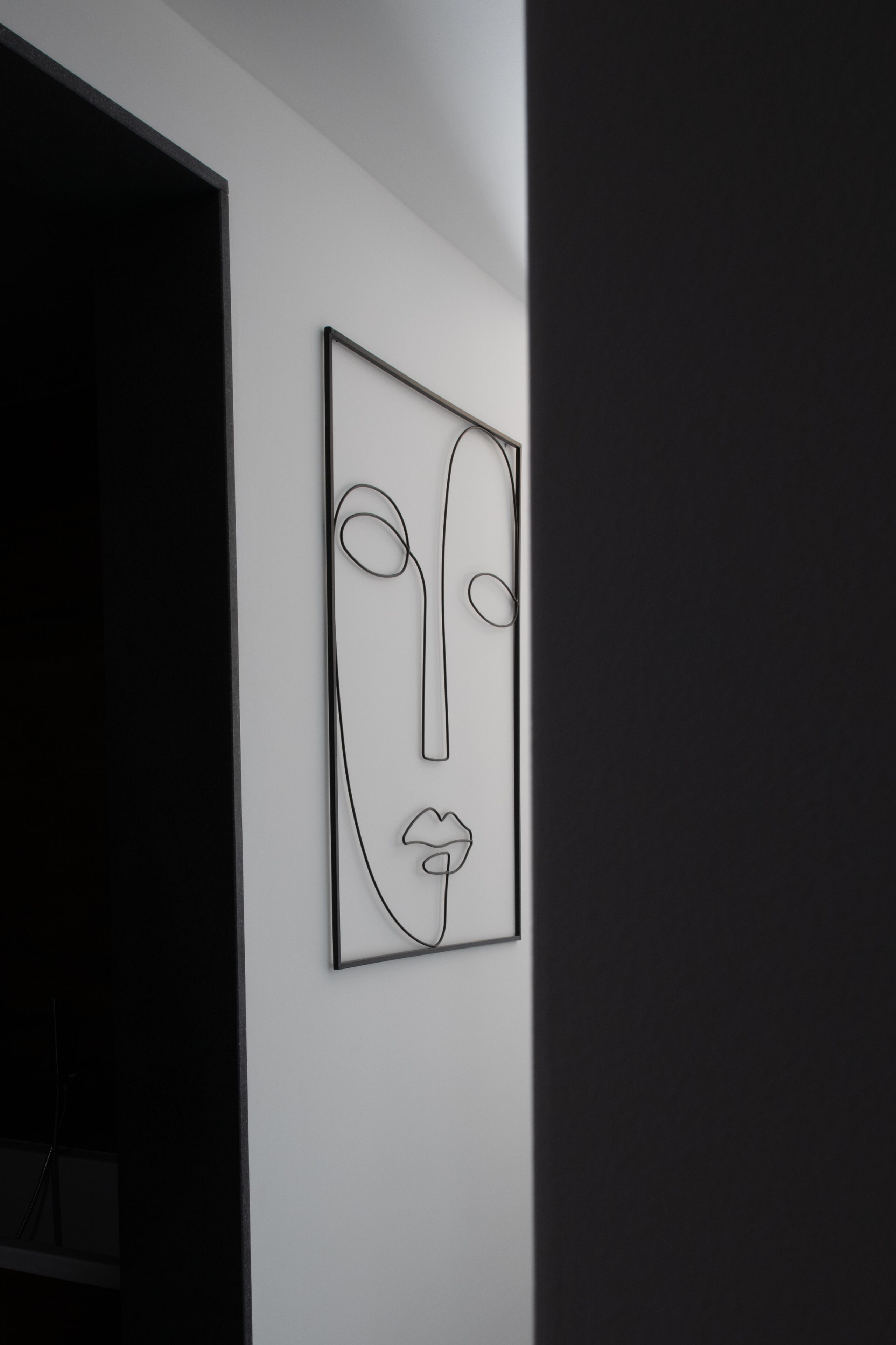 Una obra de arte mural minimalista con diseño de rostro geométrico.