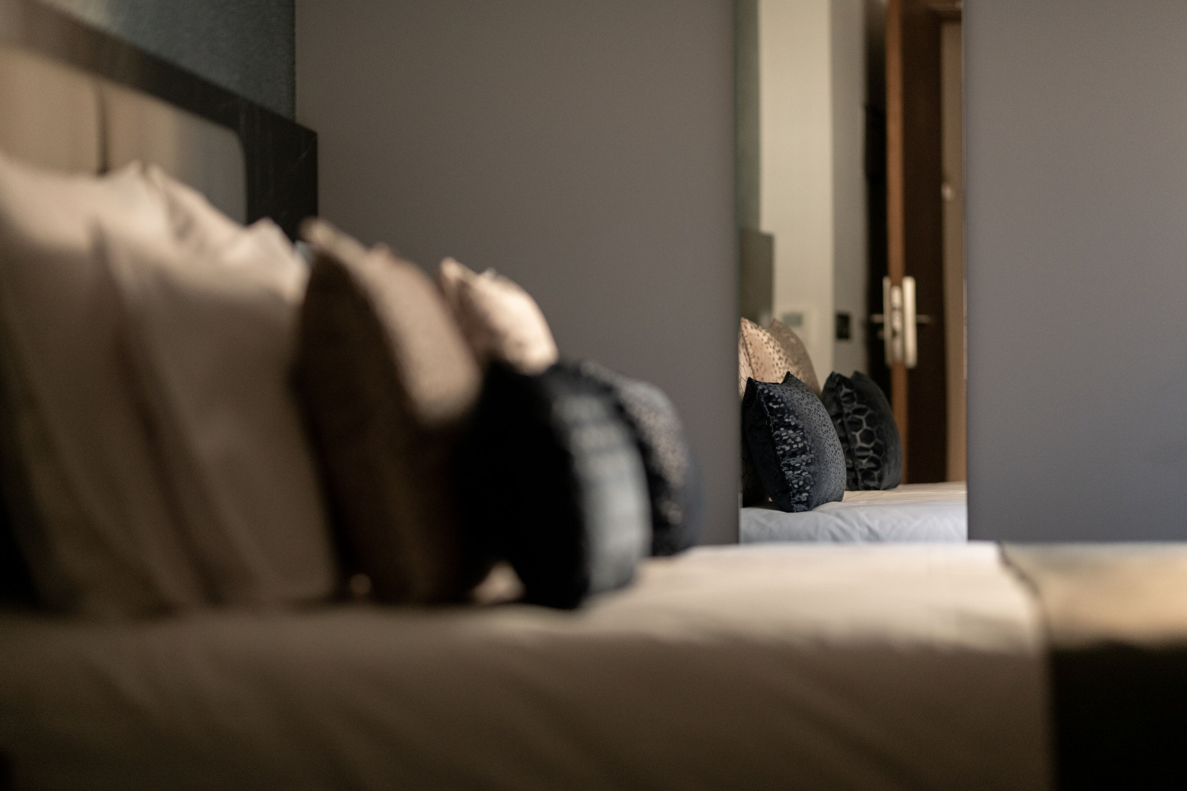 A bed with multiple pillows and a headboard.