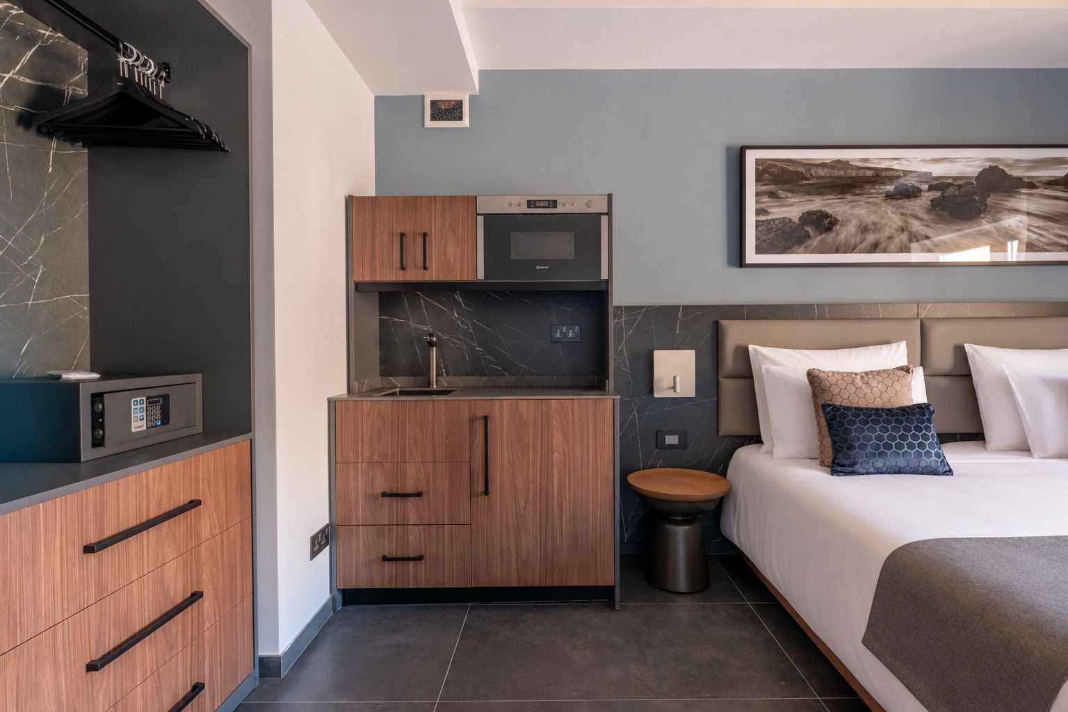 Una habitación de hotel moderna con cama, kitchenette y baño.