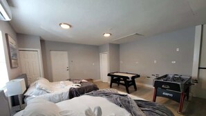 Une chambre d’hôtel avec deux lits, une table de billard et une table de baby-foot.