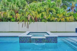 A swimming pool with a tiled edge and a built-in hot tub area. - Gorgeous 4BR| Brand new HTD Pool & Jacuzzi| 1Mile (Deerfield Beach)