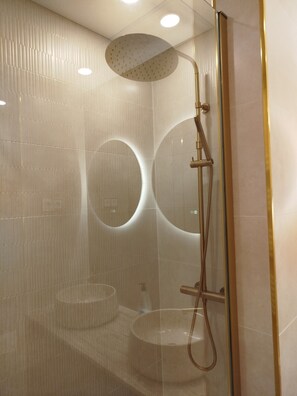 A modern shower with a handheld showerhead and a handheld hose.