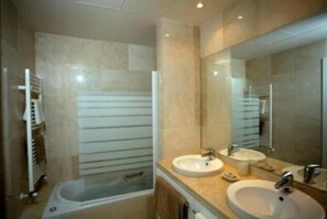 Tina con regadera, secadora de cabello, bidet, toallas 