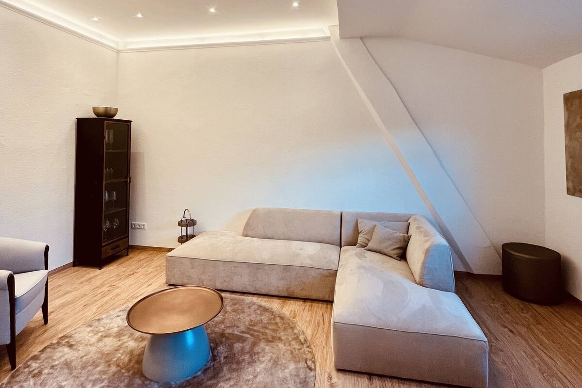 Una sala de estar moderna con un sofá modular, una mesa de centro y un mueble.