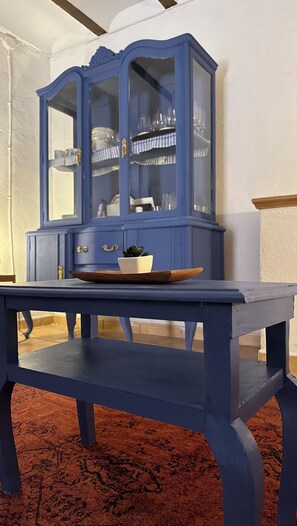 A traditional cabinet with ornate details sits atop a sturdy table, perfect for displaying decorative items.