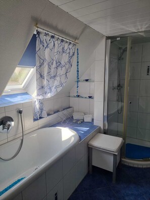 Bathtub, hair dryer, towels, toilet paper