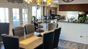A spacious dining area with a wooden ceiling, a chandelier, and a large rug. - Staycation Home minutes to all Pheonix has to offer (Glendale)