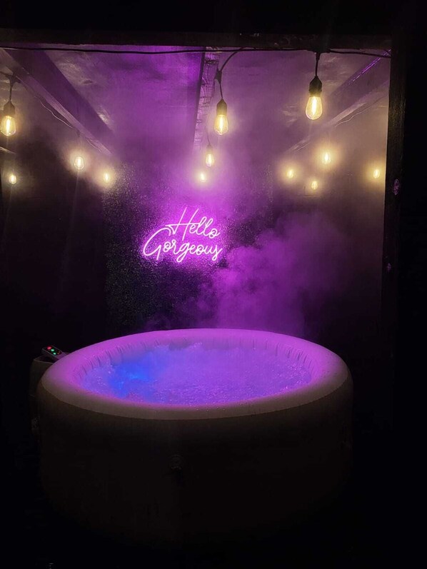 A hot tub with a neon sign that reads "Hello Gorgeous" and a mist effect. - Birmingham Airport Luxury3brhome (Birmingham)