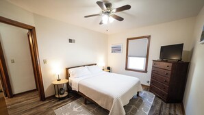 A bedroom with a bed, bedside table, lamp, dresser, TV, and a ceiling fan. - 2 E-Bikes & Kayaks included & No Cleaning Fees!! (Clear Lake)