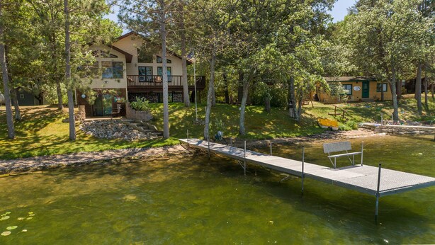 A lakeside property with a dock, a house, and a boat.