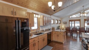 A spacious kitchen with wooden cabinets, stainless steel appliances, and a large island.