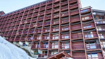 Un hotel de varios pisos con fachada roja y balcones.