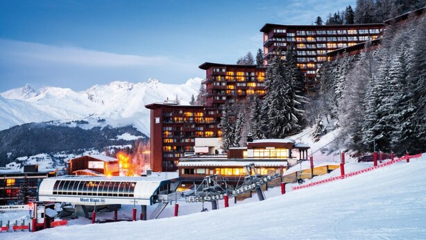A snow-covered mountain resort with modern buildings, a ski lift, and a gondola lift. - Résidence Le Varet (Bourg-Saint-Maurice)