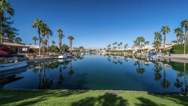 A marina with boats docked, surrounded by palm trees and a clear blue sky. - Large House in Lake La Quinta Community. Gated with Security Guard, Private Pool (La Quinta)