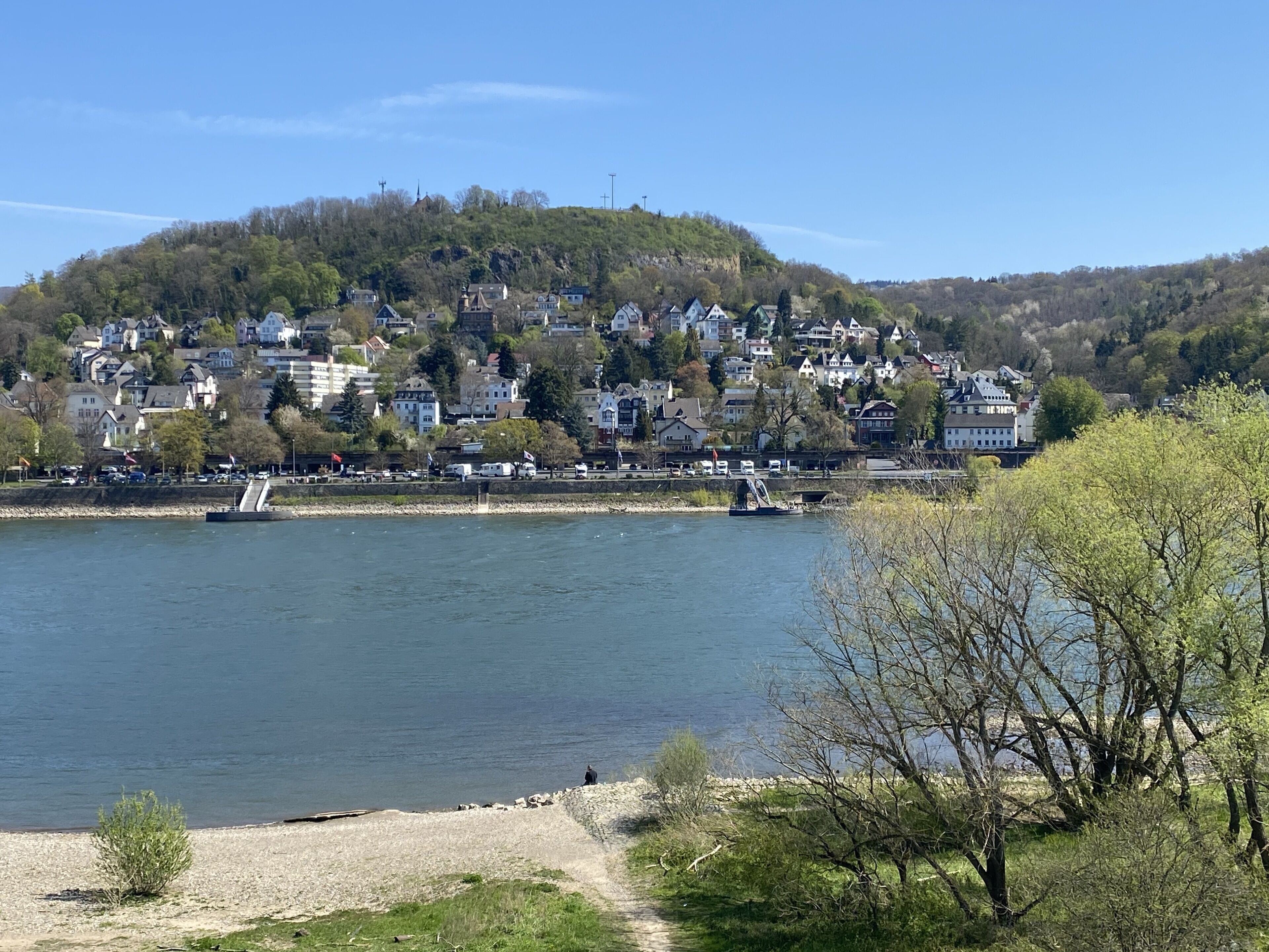 A lakeside town with residential buildings, a dock, and a clear sky.