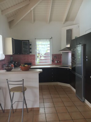 Enjoy casual dining at this kitchen with a central island, oven, and stainless steel refrigerator.