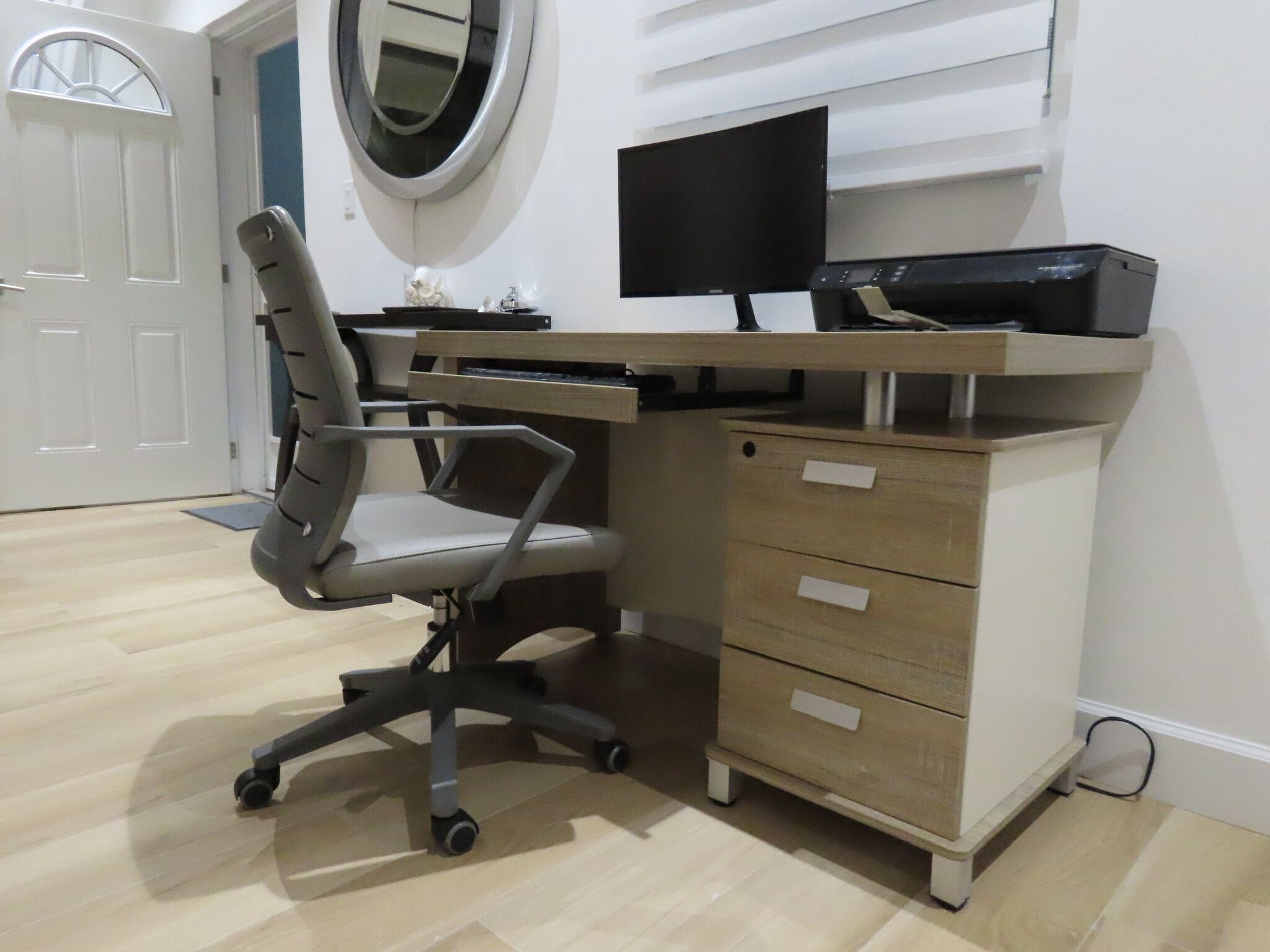 A home office setup with a desk, chair, and computer.