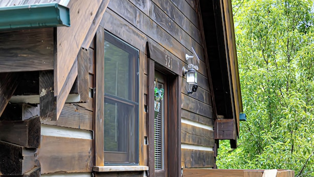 Ein rustikales Blockhaus mit einer Holzdiele und einem Steinfundament.