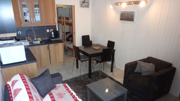 Um espaço compacto para viver com cozinha compacta, área de refeições e sala de estar.