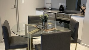 A modern kitchen with a central island, stainless steel appliances, and a built-in oven. - Sandton Smart Apartment Fourteen (Sandton)