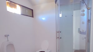 A bathroom with a urinal, toilet, and glass-enclosed shower stall. - Room with Panoramic view in the Uros - Lake Titicaca (Puno)