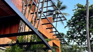 A modern building with a wooden facade and a metal staircase. - Bahari Suites (Ilhabela)