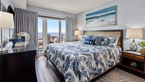 A hotel room with a large bed, a desk, a chair, and a view of the ocean. - Updated oceanfront condo w/pool, great location near Main St and other attractions (North Myrtle Beach)