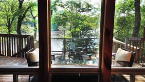 A wooden deck with outdoor seating and a view of a lake.