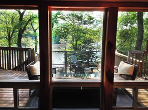 A wooden deck with outdoor seating and a view of a lake.