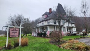 Ein großes, historisches Haus mit einem markanten Turm und einem Schild, das 'The Gallets House Bed & Breakfast' anbietet.
