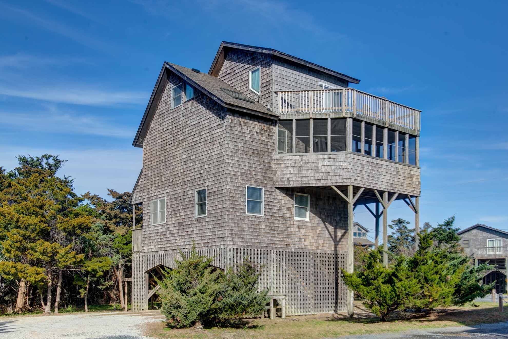Une maison en bois à plusieurs étages, dotée d’un balcon à l’étage supérieur.