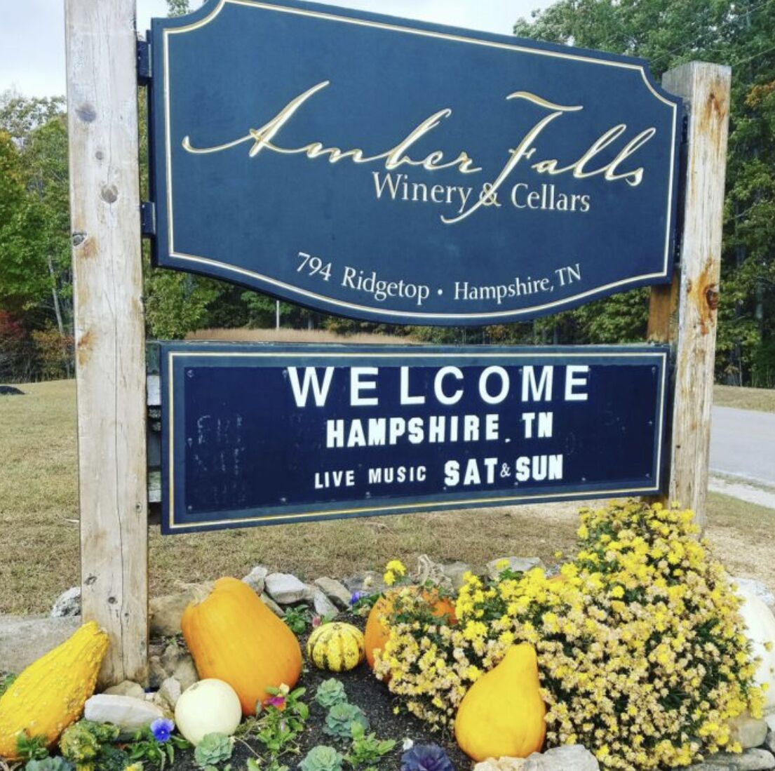 Une enseigne indiquant le nom du domaine viticole et des caves « Amber Falls Winery & Cellars », avec un message de bienvenue adressé à la ville de Hampshire, dans le Tennessee, et mentionnant la présence de concerts les samedis et les dimanches.