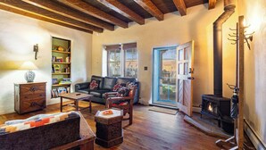 A cozy living room with a fireplace, wooden furniture, and a bookshelf.