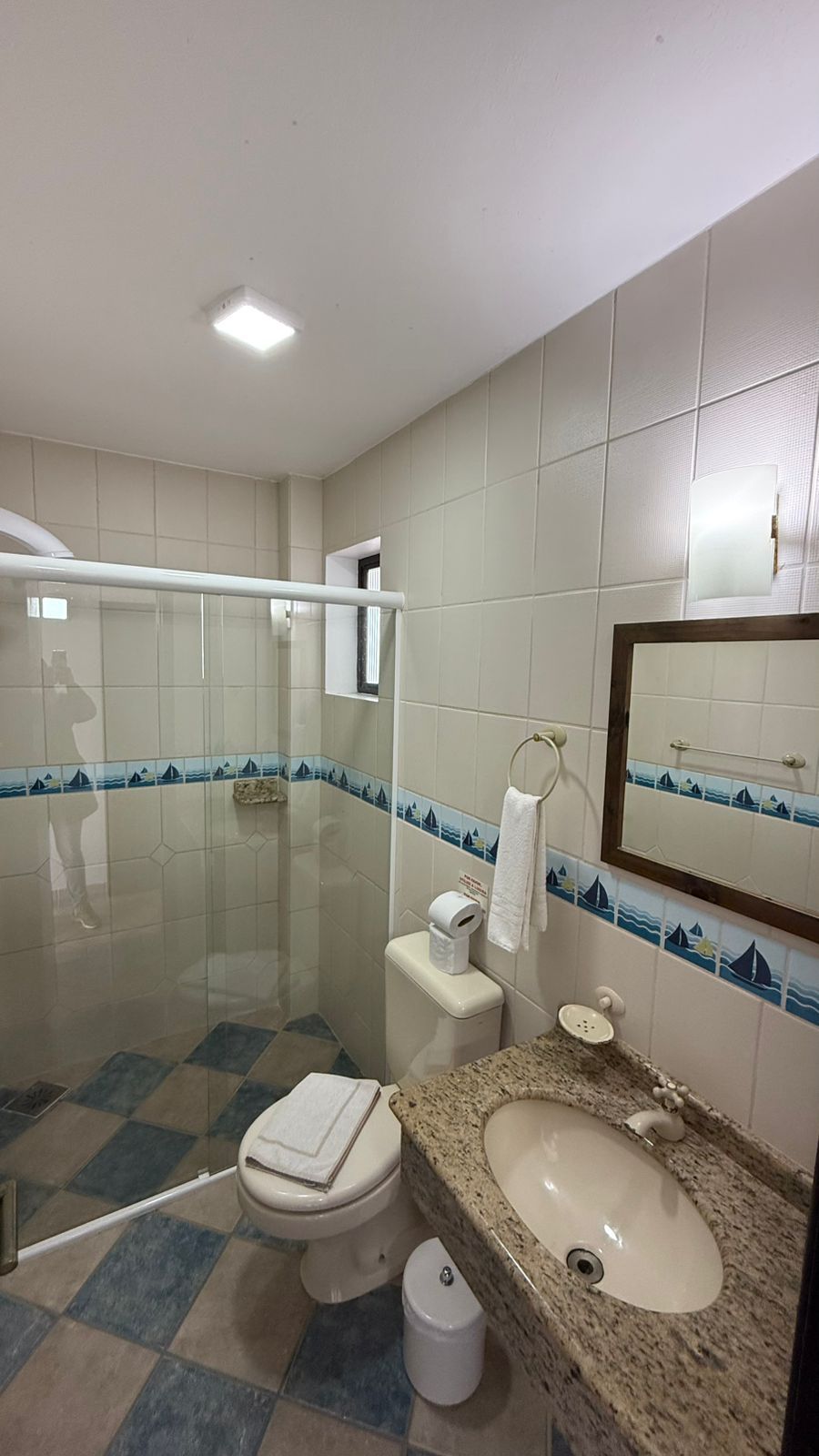 Een badkamer met toilet, wastafel en douche.