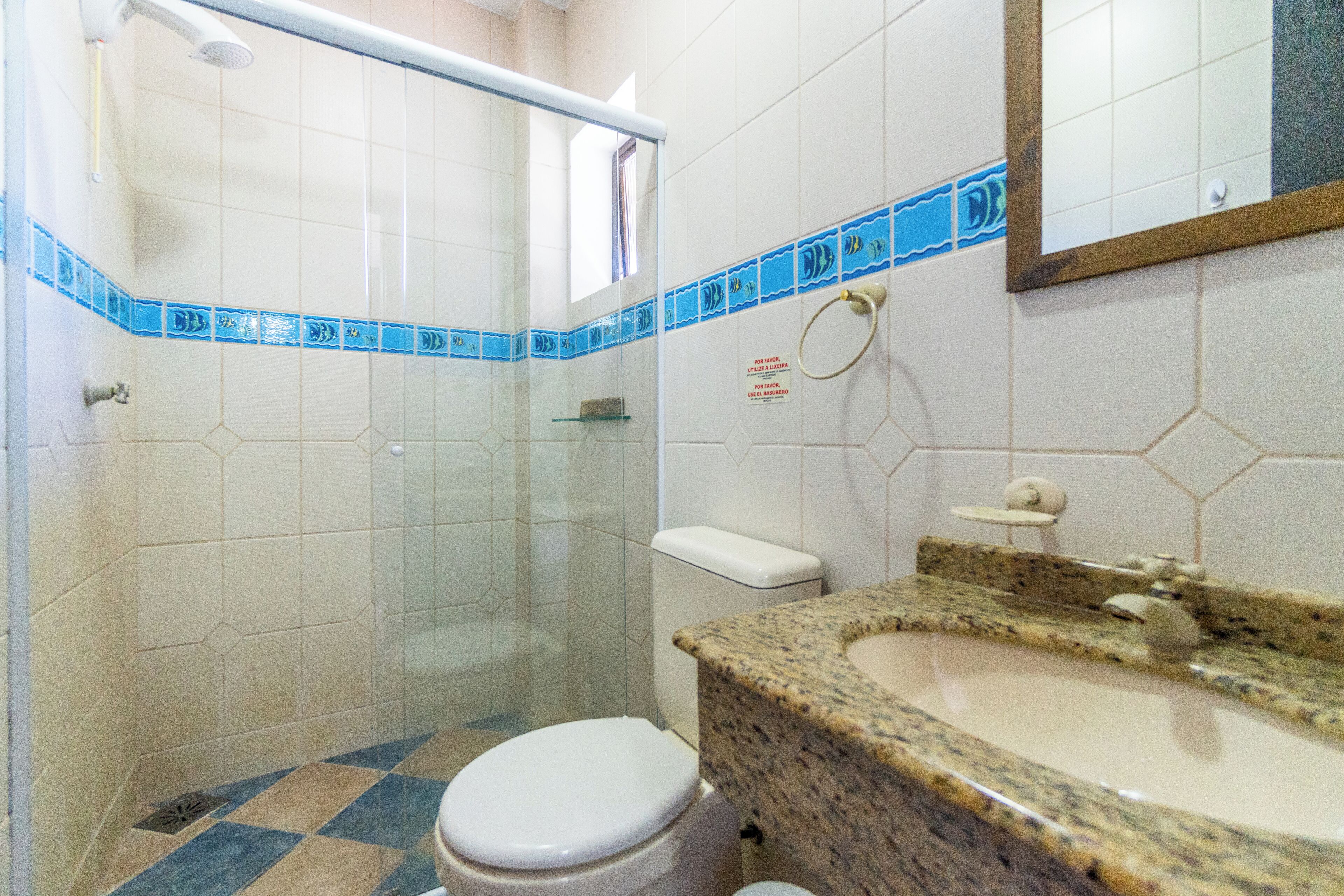 Une salle de bain avec une douche, des toilettes et un lavabo.