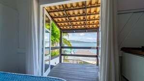 Un dormitorio con vista al mar a través de una puerta abierta.