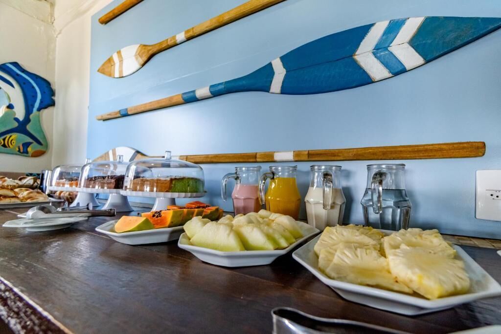 Ein Frühstücksbuffet mit verschiedenen Speisen und Getränken, inklusive einer Wand mit dekorativen Holzschubern.