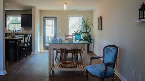 Una cocina amplia con comedor, piso de madera y ventilador de techo.