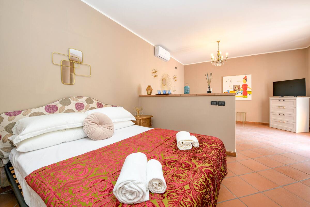 Ein Hotelzimmer mit Bett, Schreibtisch, Fernseher und Bad.