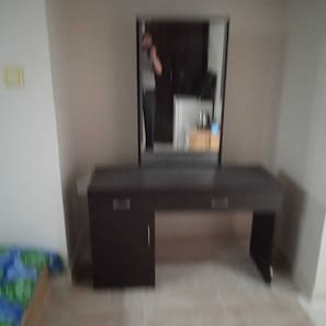 A room with a dark wooden desk, a mirror, and a small cabinet. - Ali Jasem Group (Doha)